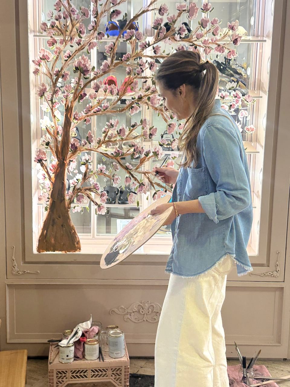 Florencia pintando mural de árbol de cerezos en flor