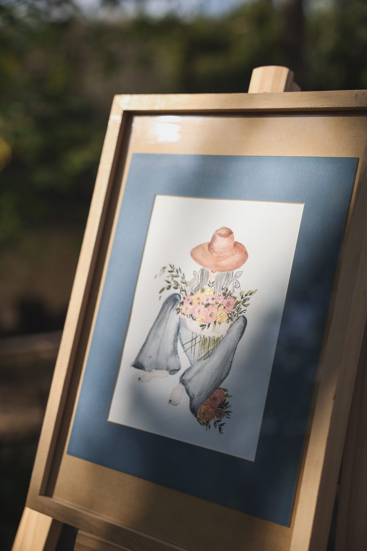 Acuarela enmarcada: figura con sombrero y flores